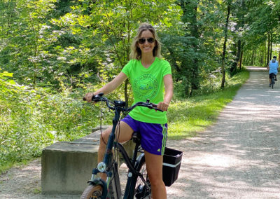 Young lady riding electric bike on a bike trail